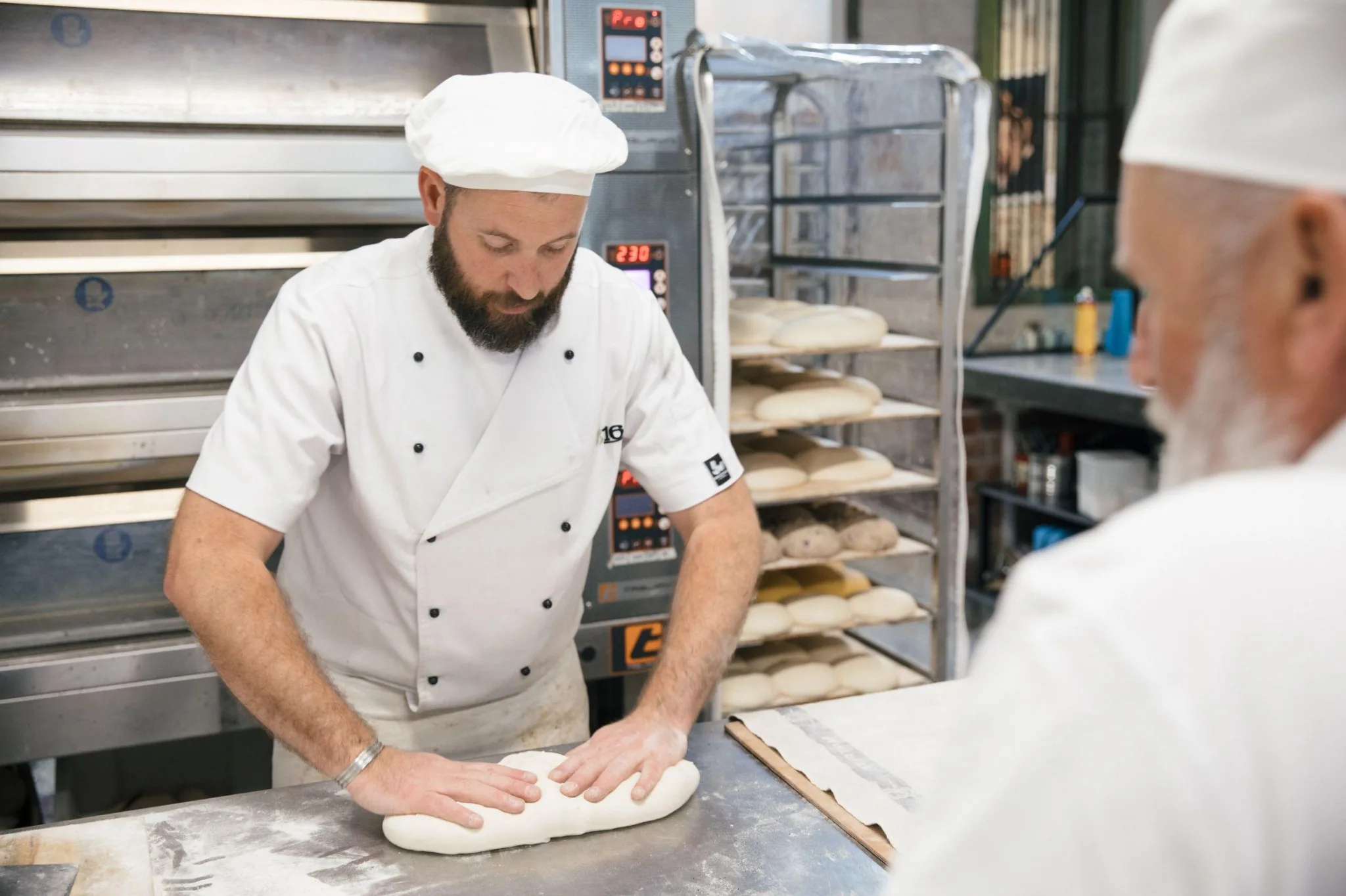 Baker thực hiện kỹ thuật tạo hình bột bánh mì trong xưởng bánh – minh họa Technical Assessment