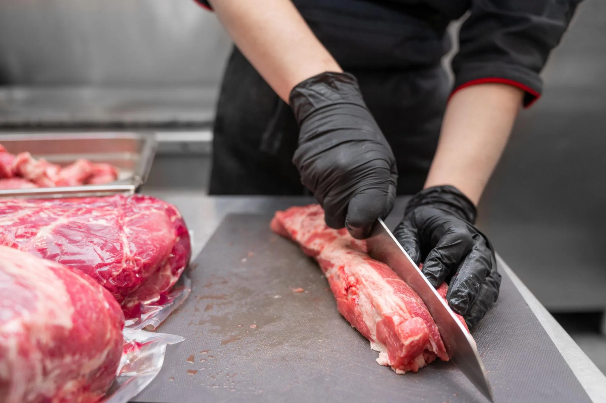 Thợ Butcher sử dụng dao cắt và pha lóc thịt bò trong cơ sở chế biến thịt