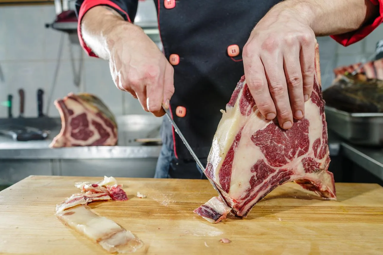 Butcher sử dụng dao lọc mỡ và cắt tỉa thịt bò
